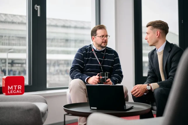 Besprechung im Team, auf dem Tisch steht der rote MTR-LEGAL-Würfel