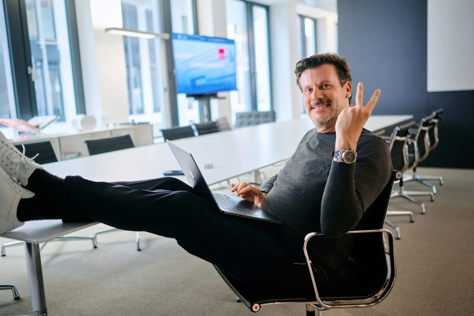 Kollege arbeitet entspannt mit dem Laptop in der Lounge