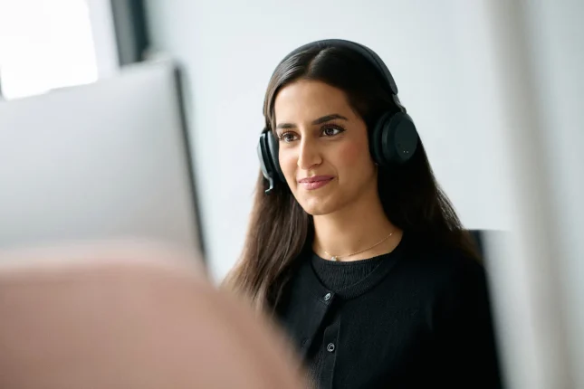 Kollegin mit Headset arbeitet konzentriert am Bildschirm