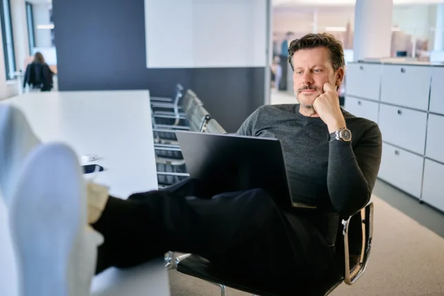 Kollege macht mit dem Laptop eine entspannte Pause in der Lounge