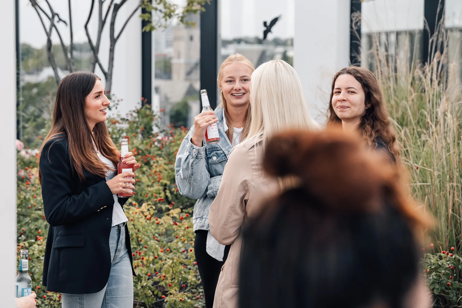 Kolleginnen unterhalten sich lachend auf der begrünten Dachterrasse